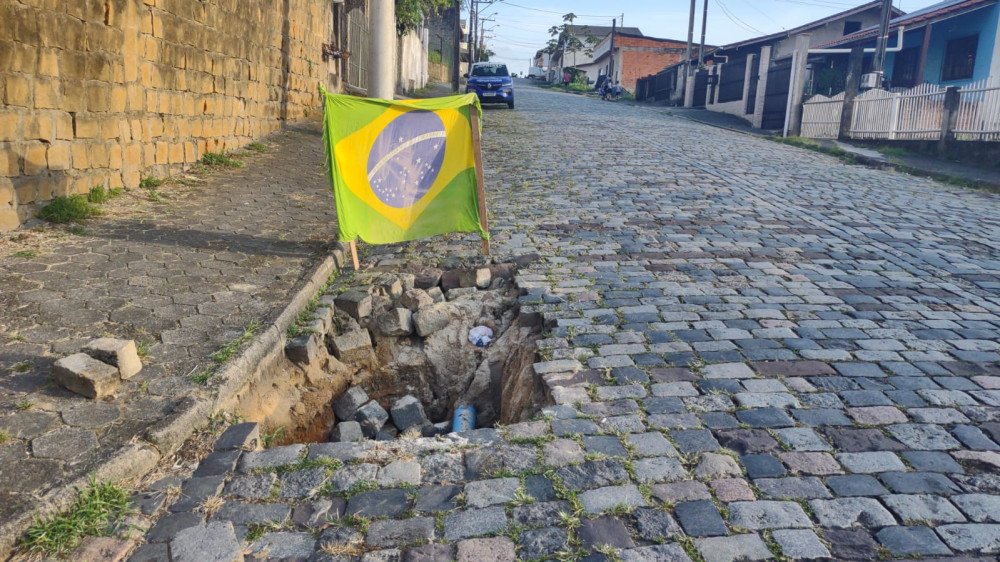 Vídeo: Moradores colocam bandeira para sinalizar buraco em rua de Blumenau