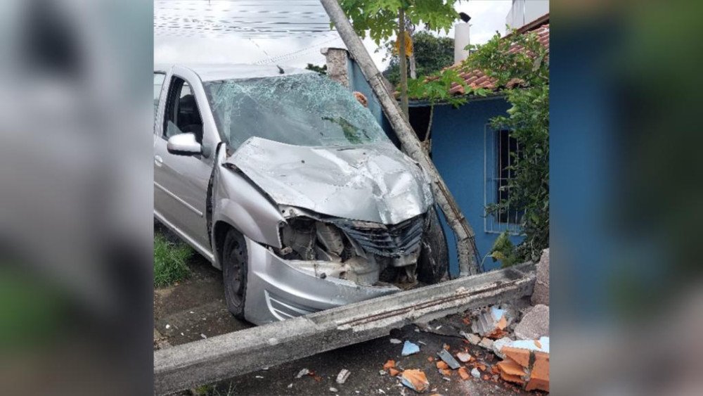 Duas pessoas são hospitalizadas após carro bater contra muro, postes e casa em Blumenau