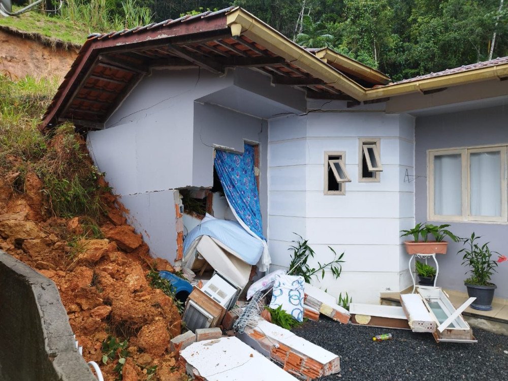 Deslizamento de terra atinge casa em Timbó; criança fica presa aos escombros e é resgata