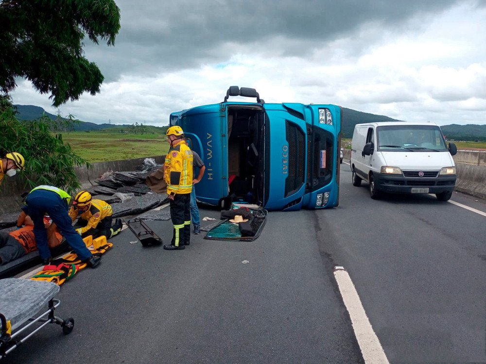Caminhão carregado tomba na BR-470 e carga de madeira atinge ciclista