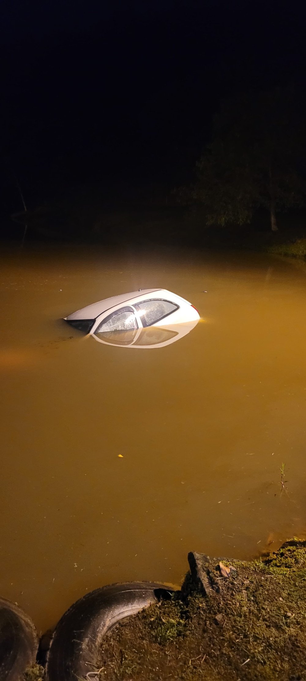 Saída de pista termina com carro dentro de lagoa em Ilhota